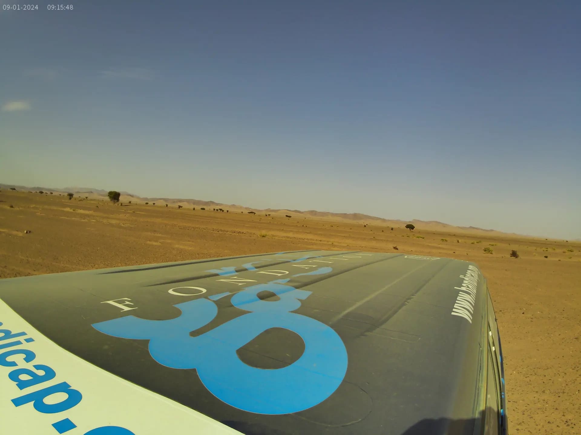 Capot du véhicule avec le logo Fondation Garches dans le désert