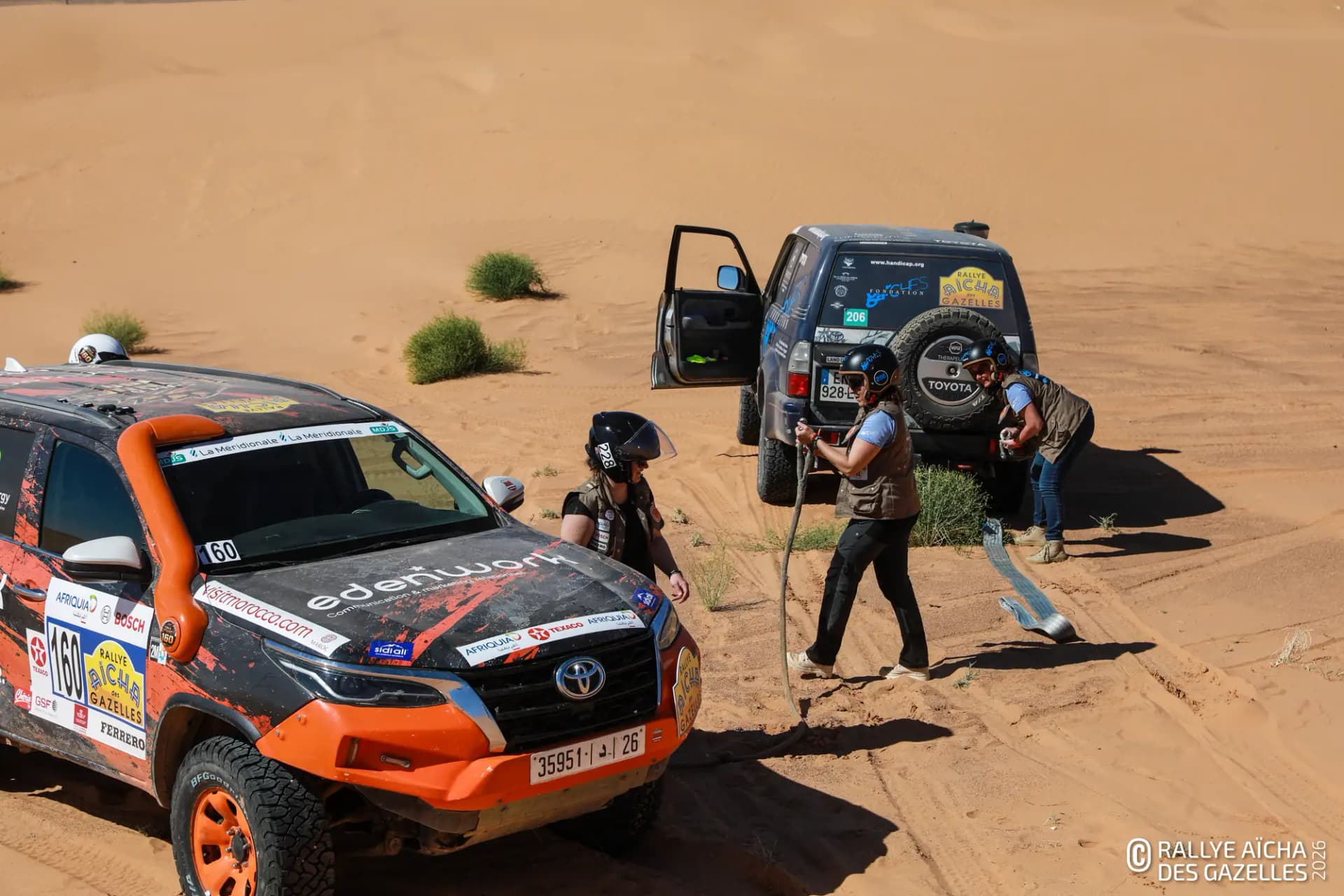 Deux équipages s'entraident pour désensabler un véhicule dans les dunes, étape 1