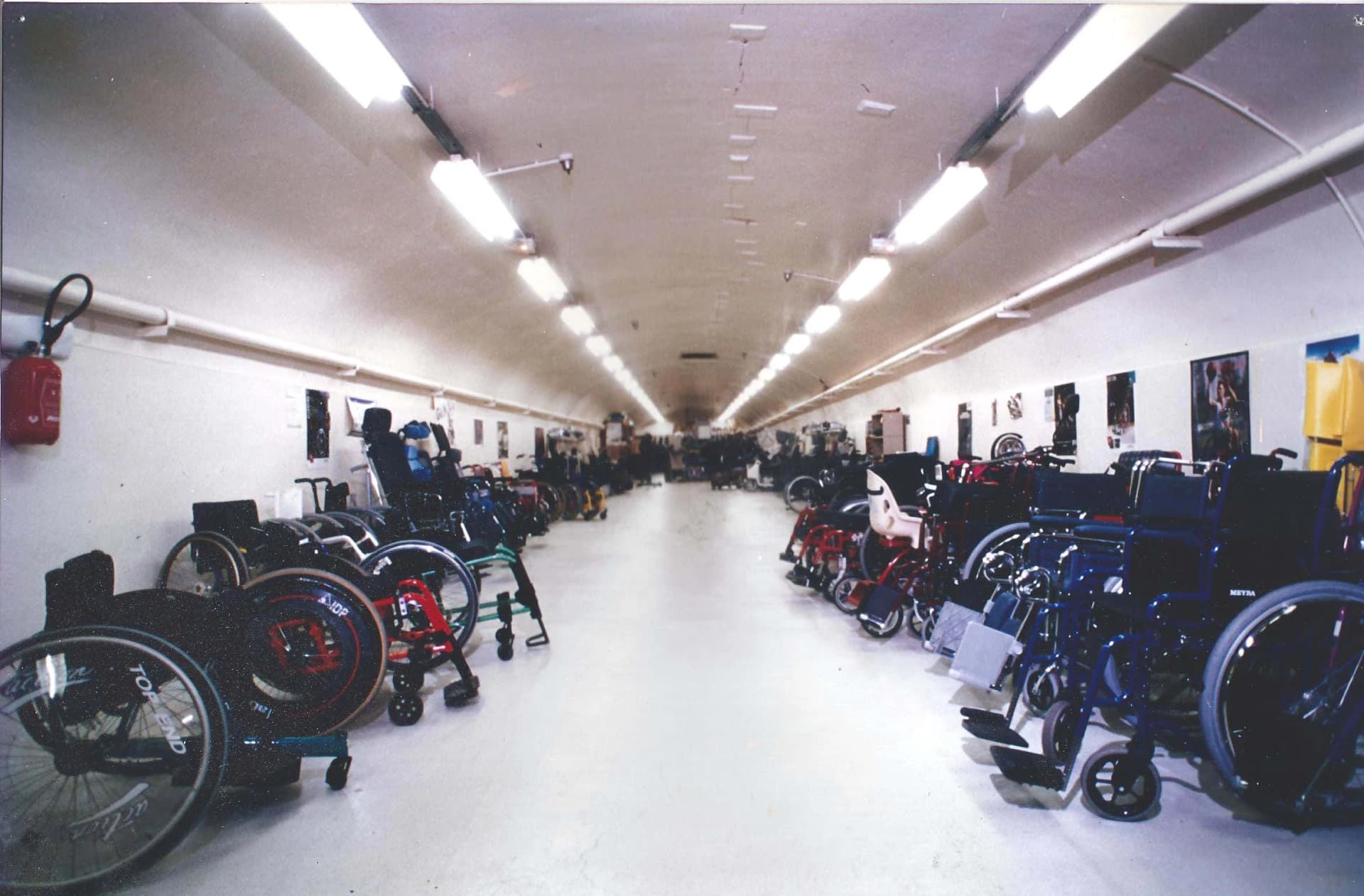 Mains sur les roues d’un fauteuil roulant, symbolisant l’usage et le choix du matériel.